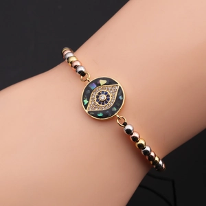 Detail showing the Evil Eye charm with zircons, colorful shell inlay, and adjustable band