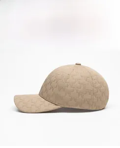 Side view of beige baseball cap featuring an all-over jacquard M pattern and curved brim