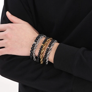 Close-up of double-layer men's bracelet with black matte beads and metallic chains on wrist