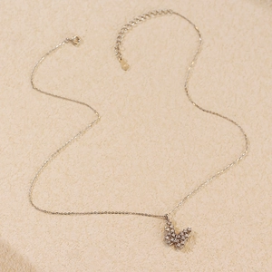 Detail of silver S925 butterfly pendant with hollow design and sparkling zircon stones