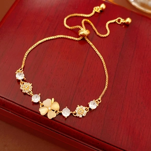 Detail of adjustable gold plated bracelet with opal clover and zircon flower charms