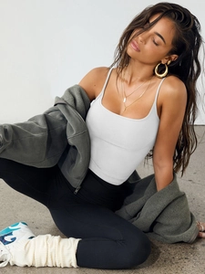 Detail of white slim fit tank top paired with gray fleece jacket and black yoga pants