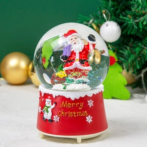 Close-up of Santa Claus snow globe with a red Merry Christmas base and glitters