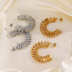 Exaggerated C-shaped 18K gold and silver plated twisted earrings on silk fabric