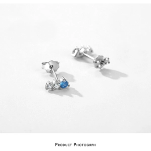 Detailed macro view of S925 sterling silver stud earrings with blue and white zircon stones