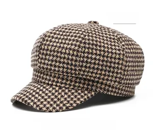 Detailed view of khaki houndstooth fabric texture on a retro newsboy style octagonal hat