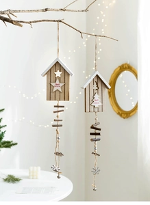 Detail of wooden Christmas wind chimes with star and tree designs on a rustic branch