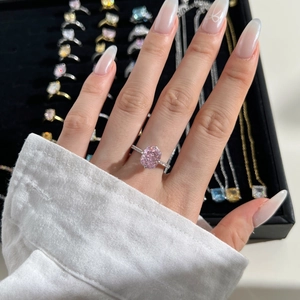 Detailed view of pink oval crystal ring with micro-paved band on a jewelry tray