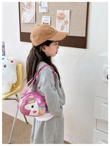 Girl wearing a pink unicorn crossbody bag with rainbow design and heart detail