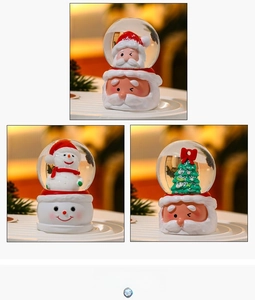 Close-up of Santa and Snowman crystal globes with relief bases and festive details