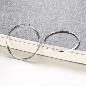 Polished silver oversized hoop earrings in minimalist style with shiny metallic finish