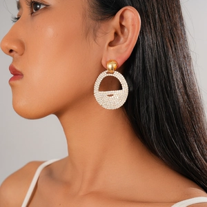 Close-up of elegant gold hoop earrings with sparkling rhinestones worn by a fashion model