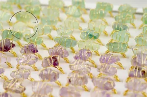 Detailed row of handmade wire-wrapped natural crystal rings in gold finish