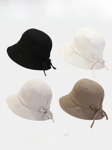 Detail of textured fabric fisherman hats in four colors with decorative side bows