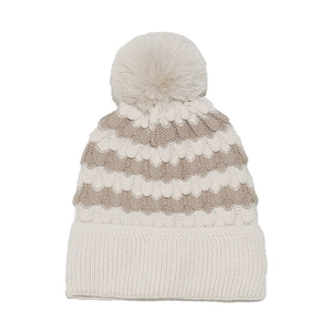 Detailed close-up of wave-patterned knit beanie with a fluffy faux fur pom-pom