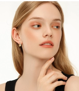 Detailed close-up of golden hoop earrings featuring a luxury moissanite fringe on model