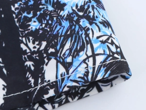 Detail of tropical palm leaf print on fabric with neat stitching on the dress sleeve
