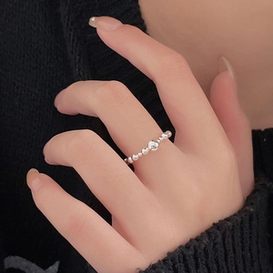 Detail of 925 sterling silver beaded open ring shown on a model against black background