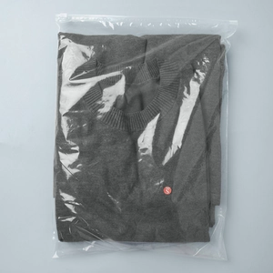 Detail of grey knitted short sleeve top folded in packaging with Size S label