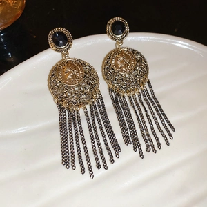 Detailed macro shot of vintage portrait coin earrings with black metal chain tassels