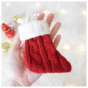 Close-up of red and white cable knit Christmas stocking ornament held in hand
