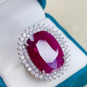 Oval cut ruby ring with a sparkling diamond halo set in a premium blue velvet jewelry box