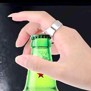 Gros plan d'une bague décapsuleur en acier inoxydable ouvrant une bouteille de bière.