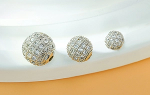 Detailed view of three gold plated cubic zirconia round spacer beads for DIY jewelry
