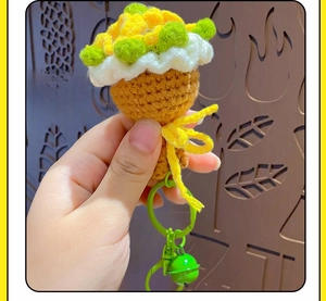 Close-up of handmade crochet sunflower keychain with yellow petals and green metal ring