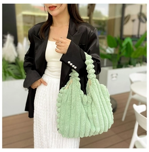Detail of light green plush tote bag featuring soft faux fur with vertical stripe texture