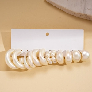Set mit cremefarbenen Perlen- und Acryl-Ohrringen auf einer weißen Displaykarte