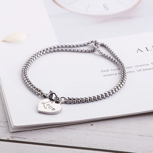 Dettaglio del bracciale a doppio strato in acciaio con ciondolo a cuore Love inciso