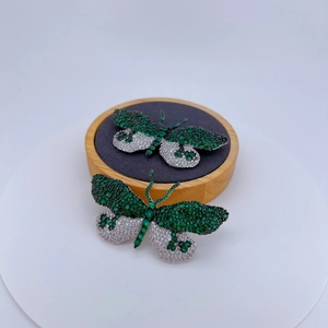 Élégante broche papillon avec oxydes de zirconium verts et blancs sur monture argentée