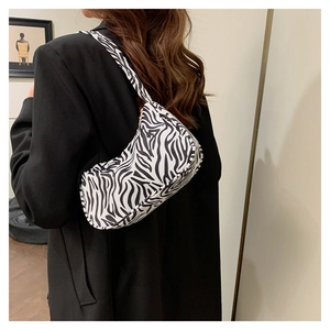Gros plan du sac à bandoulière zébré en toile et cuir PU au design rétro et tendance
