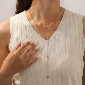 Double-layered gold-plated heart pendant necklace with shimmering zircon accents on model