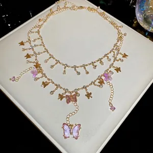 Double-layered gold necklace featuring purple crystal bows and metal butterfly charms