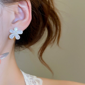 Detailed shot of floral zircon earrings with delicate petal texture and pearl center