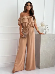 Detail of off-the-shoulder ruffle neckline on earthy brown wide-leg jumpsuit with belted waist
