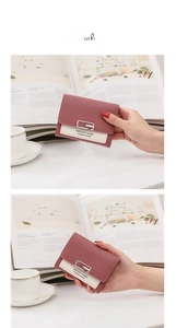 Detail of a minimalist square buckle wallet featuring pink and cream leather color block