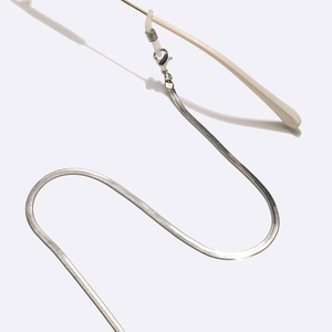 Close-up of silver snake chain eyewear strap with adjustable rubber loop and metal clasp