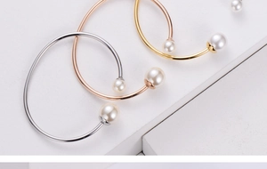 Detailed view of minimalist open cuff bracelets in gold, silver, and rose gold with pearls