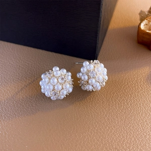 Macro shot of cluster pearl earrings with clear zircons and gold-plated finish