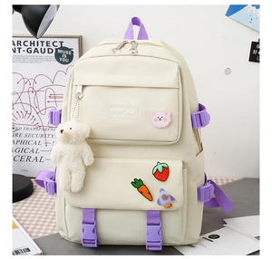Detail of off-white school backpack with cute plush bear pendant and decorative pins