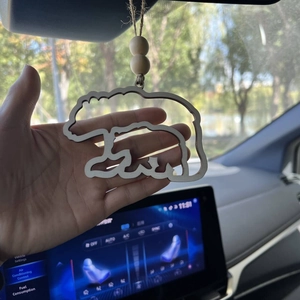 Detail of wooden mother and baby bear hanging ornament with rustic beads on car mirror