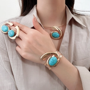 Detail of vintage turquoise resin jewelry set featuring gold spiral design on model