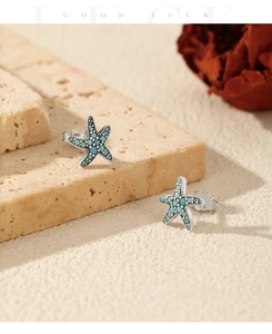 Close-up of S925 sterling silver starfish stud earrings with turquoise beads and hallmark