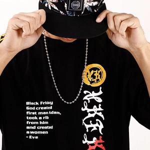 Detail of long stainless steel ball chain necklace worn over a black streetwear t-shirt
