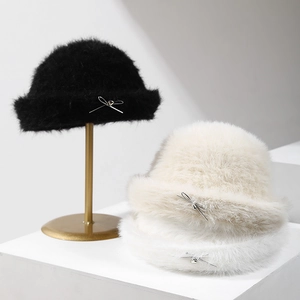 Plush faux rabbit fur bucket hats with bow charms in black, beige, and white colors