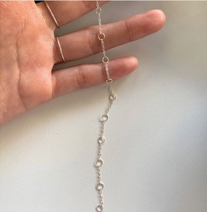 Close-up of S925 sterling silver knotted link chain bracelet held by a hand