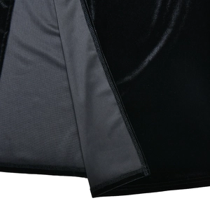 Détail de la robe en velours noir montrant la doublure lisse et la couture de la fente